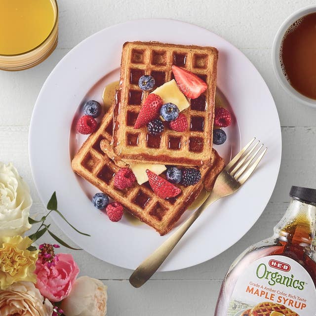 Waffles with berries and a cup of orange juice