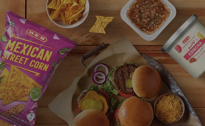 Valentines day kitchen and dining items including a scalloped heart shape platter, pink travel mug, red and white dish towels with the shape of Texas on them and a Texas shaped serving platter