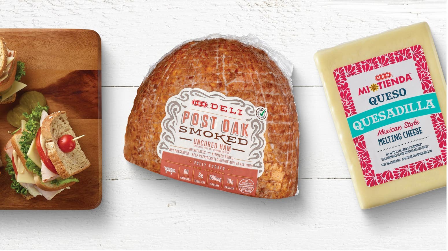 H‑E‑B Mi Tienda Mexican Style Melting Cheese, H‑E‑B Deli Post Oak Smoked Turkey Breast, and sliced sandwich toppings like lettuce, tomato, onions, and pickles on a cutting board.