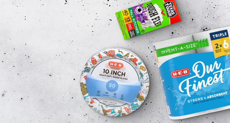 H‑E‑B products on a white background, including 10-inch heavy-duty paper plates, Our Finest strong and absorbent paper towels, and Tall Kitchen Tough Flex trash bags.