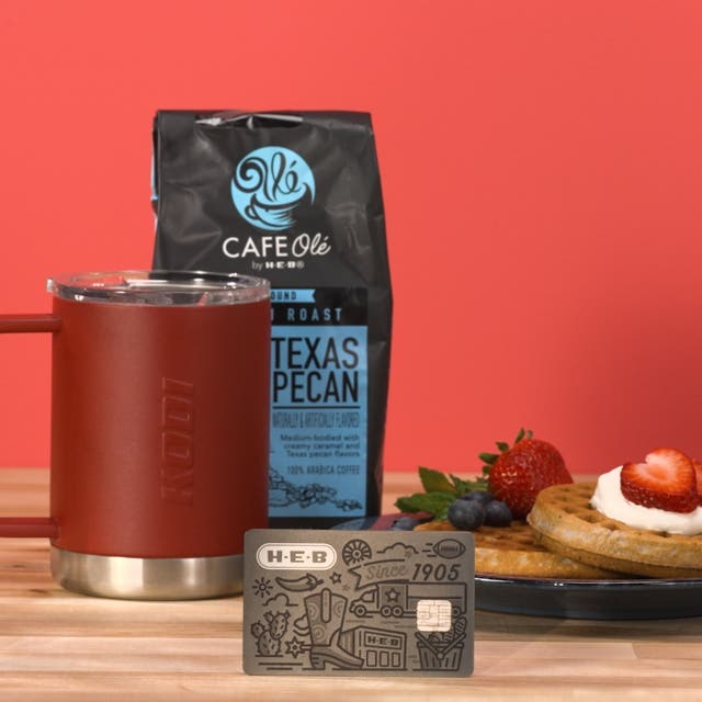 H‑E‑B Credit Card with Cafe Olé, a Kodi cup, and a plate of waffles and fruit