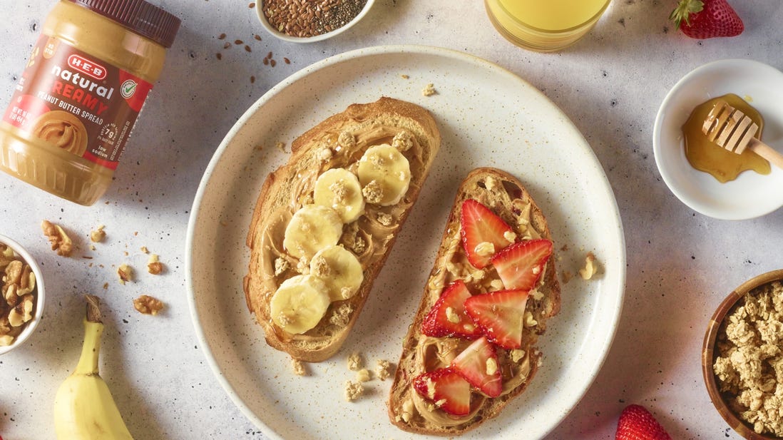 Peanut butter, banana and cut strawberries laying on a slice of bread