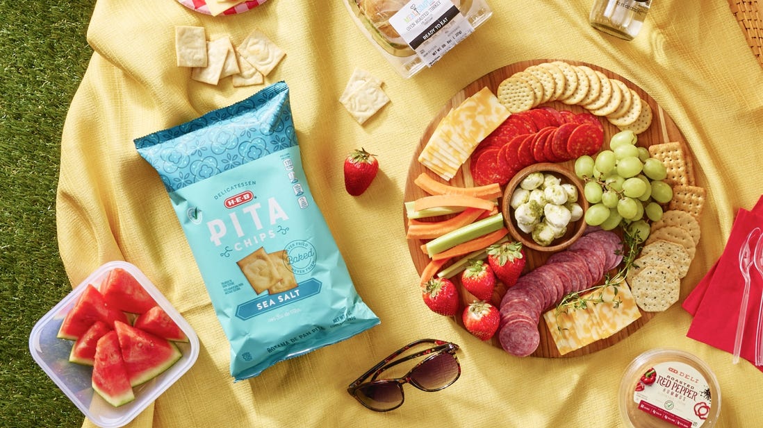 Picnic essentials, charcuterie board, pita chips, sliced watermelon