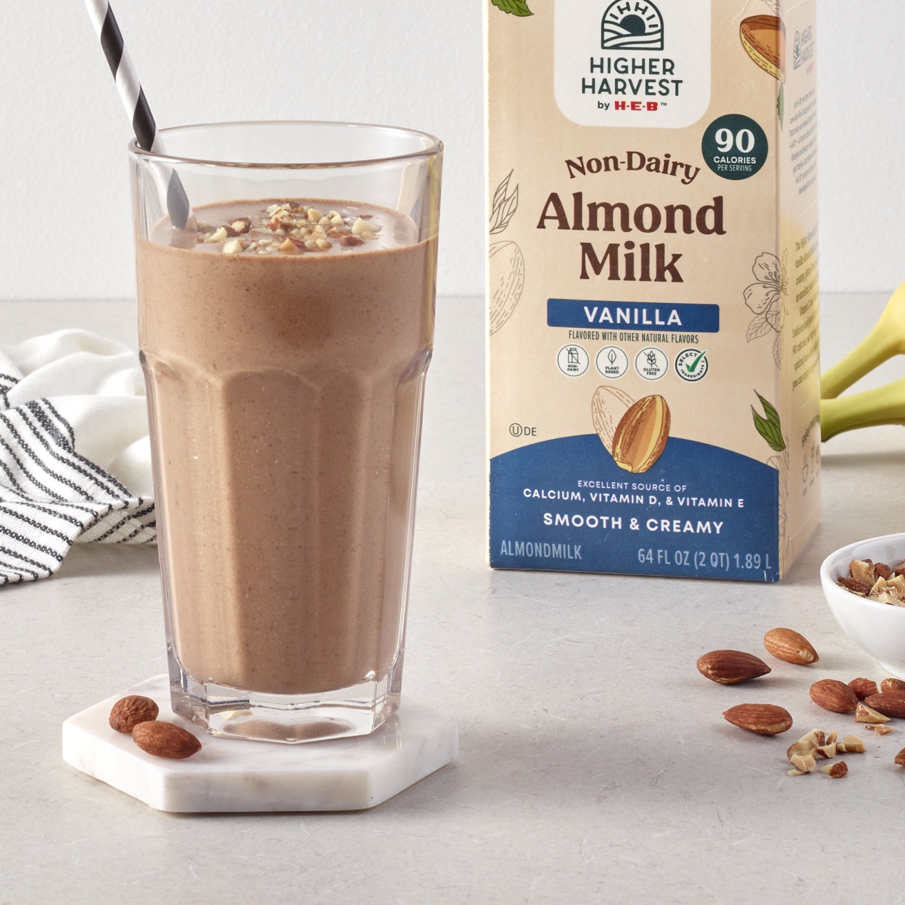 Higher Harvest by H‑E‑B Non-dairy Vanilla Almond Milk next to a smoothie in a glass
